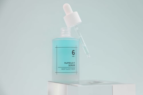 En blå serumboks med pipettlokk, merket '6 Serum, Deep Sleep Mask,' på en hvit overflate.