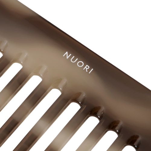 En metallhårbørste med merket "NUORI" og jevnt fordelte børster.