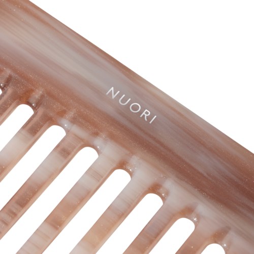 Róż comb with the brand name 'NUORI' on it, featuring wide spaced teeth.