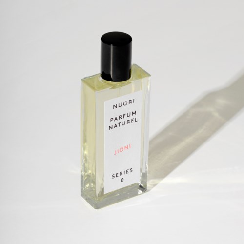 Pieni tuoksupullo, jossa musta korkki, merkintä 'Nuori Parfum Naturel Joni Series 0', heijastaa varjoa.