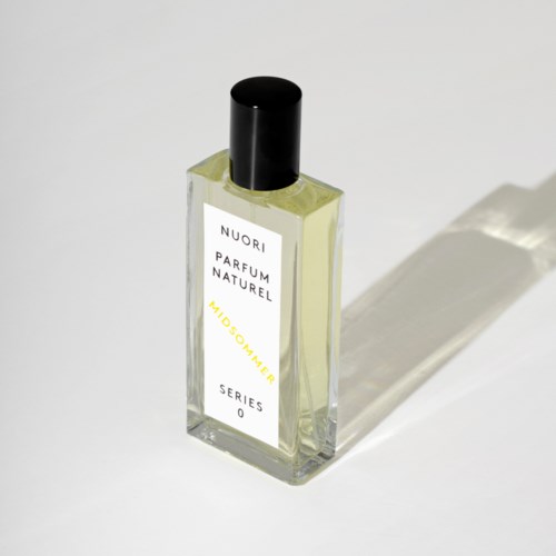 A clear bottle with a black cap, labeled with white and yellow text, casting a shadow on a white surface.