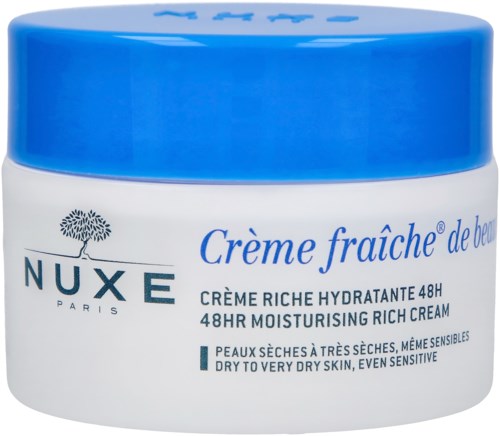 En burk med NUXE-lotion för mycket torr och känslig hud. Blå lock, vit behållare, med text på franska och engelska.