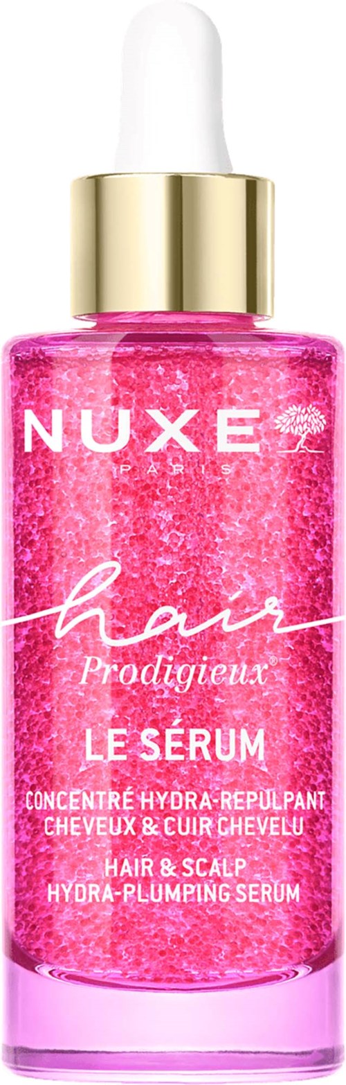 Roze haarserumfles met witte en gouden dop, gemerkt Nuxe Hair Prodigieux. Bevat hydraterende en verkwikkende ingrediënten.