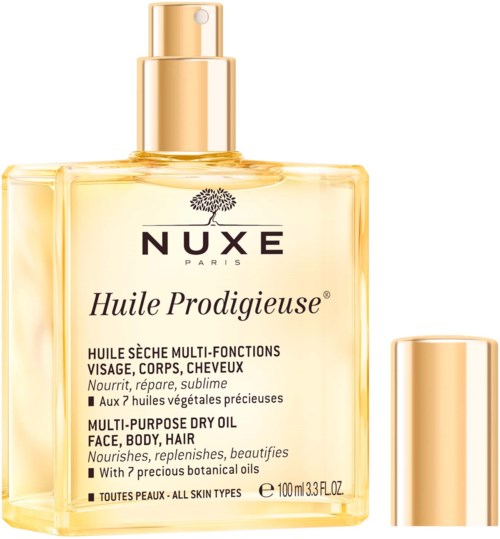 En genomskinlig flaska med guldkapsel innehåller Nuxe Huile Prodigieuse torrolja med botaniska ingredienser. Den är för ansikte, kropp och hår.