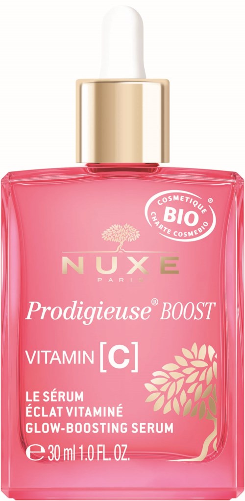 En rosa glasflaska med en guldpipettlapp, märkt som en glow-boostande serum med vitamin C från Nuxe Paris.