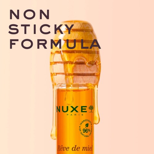 En honningkrukke med honning der drypper ned, omgivet af tekst om ikke-klæbrig formel og naturlige ingredienser.