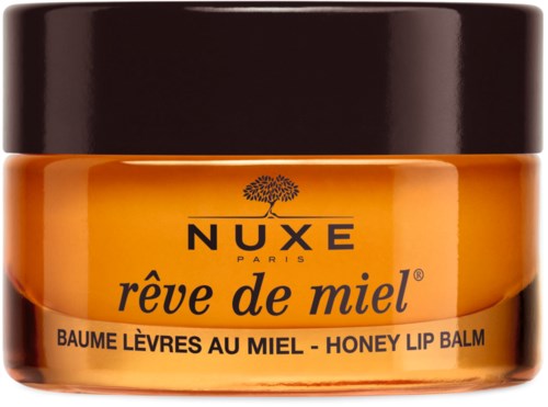 Mały pojemnik z miodowym balsamem do ust od Nuxe Paris, oznaczony 'rêve de miel'. Jest pomarańczowy z czarnym wiekiem.