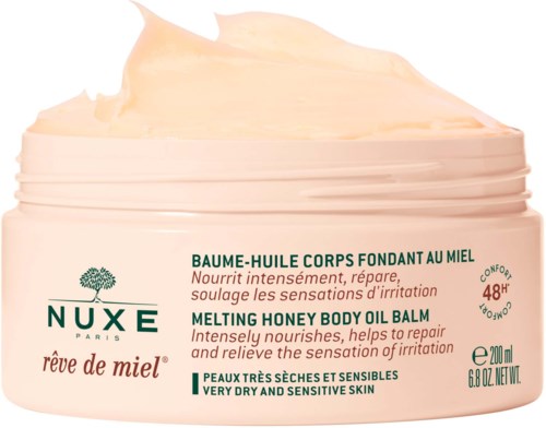 En rosa burk med Nuxe Rêve de Miel återfuktningsbalsam för torr och känslig hud. Den är honungssmakande och avsedd för lugnande och reparerande.