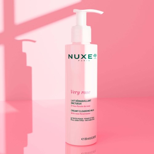 En rosa flaska med pump, märkt 'Very Rose' av Nuxe, står på en rosa bakgrund.