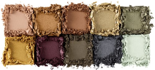 A palette of eyeshadow powders in various colors, arranged in two rows with crushed powder around each. Includes neutral, purple, black, and gray shades.