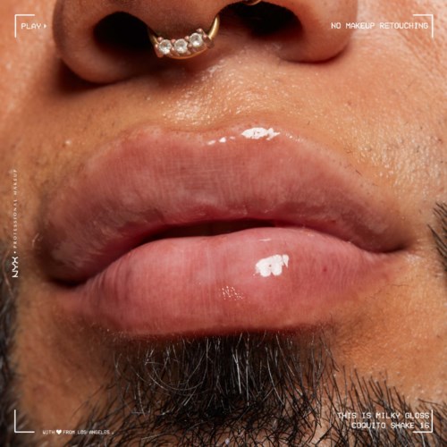 Close-up of lips with shiny gloss and a nose piercing. Skin appears textured and lips are slightly parted.