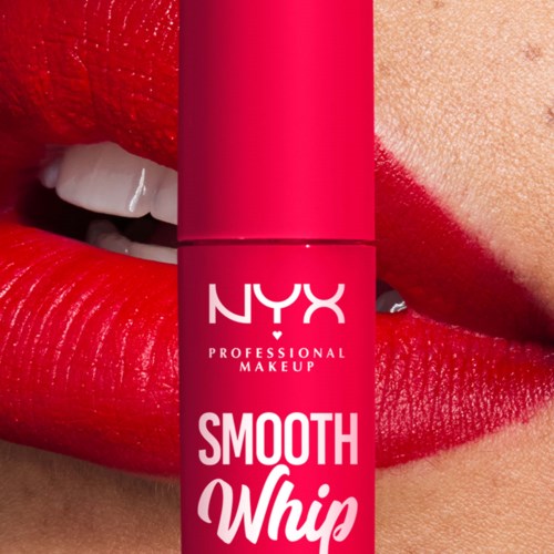 En person med rødt leppestift nær et NYX Smooth Whip sminkeprodukt på leppene og haken.