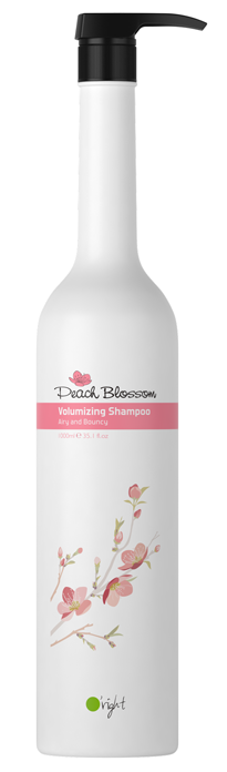 En vit flaska med Peach Blossom Volumizing Shampoo med rosa blomma och svart pump.