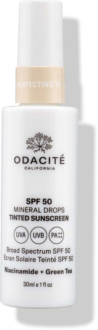 En hvit solkremflaske med spray, merket Odacité California, SPF 50, med grønt te og Niacinamide.