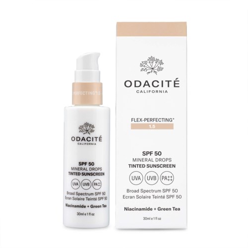 En hvit flaske med pumpe og en eske ved siden av som viser solkrem med SPF 50 og grønn te-ingredienser.