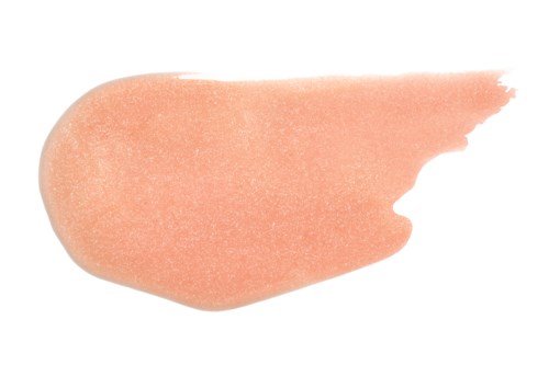 Een perzikkleurige blush met een gladde, licht glanzende textuur en oneffen randen.