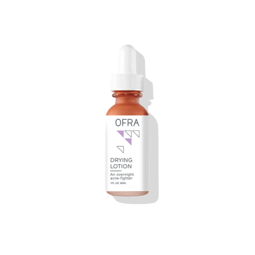 En liten flaske merket OFRA Drying Lotion for akne, har en hvit dryppelokk og en rosa væske inni.