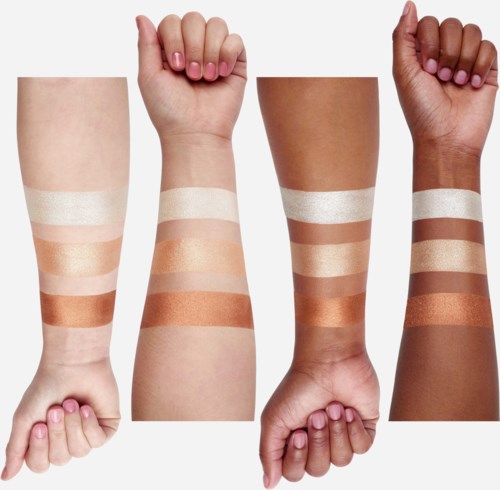 Vier Arme mit unterschiedlichen Hauttönen zeigen Make-up- oder Hautpflegeproben auf ihren Unterarmen.
