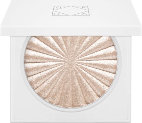 En makeup highlighter med ett solstrålsmönster i ett vitt sminketui.