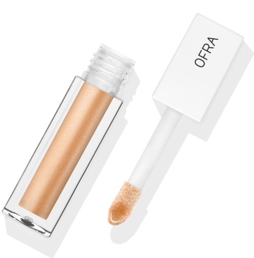 En beige concealerstift med vit lock, märkt "OFRA," på svart bakgrund.