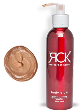 En rød kropslotionflaske med pumpe og en klat brun creme ved siden af.