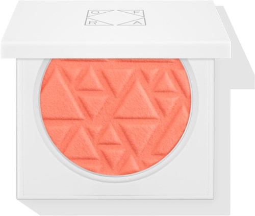 En rund blushkompakt med orangefarvet blush indeni, dekoreret med trekantsmønster. Compacten har et hvidt cover.