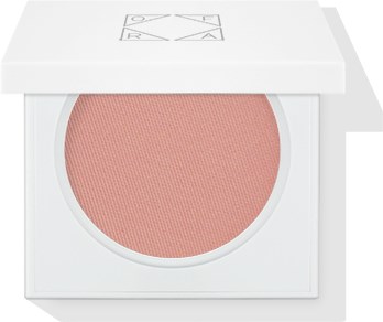 En rund rosa blush i et hvidt etui med gennemsigtigt låg, en del af makeup eller skønhedsprodukter.