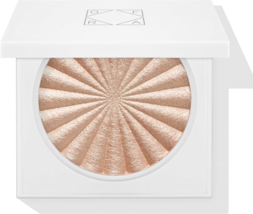 En rund makeup-kompakt med vit skal, med ett glänsande persikofärgat tryckt puder med ett solstrålningsmönster.