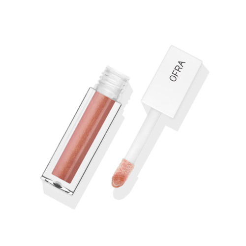 Lippenbalsemtube met witte applicator en perzikkleurige glans. OFRA op handvat.