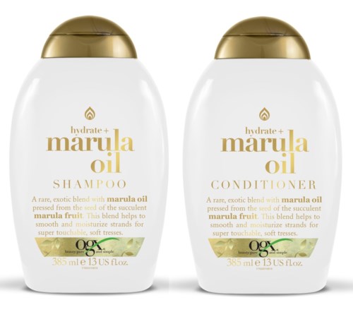 Två vita flaskor med guldkorkar, märkta som Marula Oil Schampo och Balsam, med gröna och gyllene detaljer.