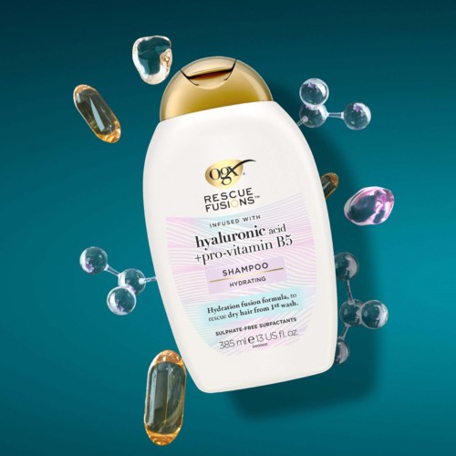 En shampoo-flaske med guldhætte omgivet af farverige kapsler og bobler.