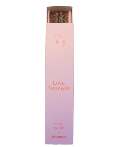 Długi różowy karton z świecami wewnątrz, oznaczony "Love Yourself" i "oh la moon."