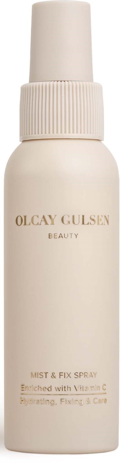 Eine weiße Flasche mit Spraykopf, gekennzeichnet Olcay Gulsan Beauty Mist & Fix Spray, angereichert mit Vitamin C.