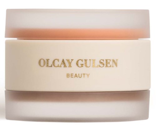 Stożkowe pojemniki z złotym napisem, oznaczone Olcay Gulsen Beauty, w neutralnych kolorach.