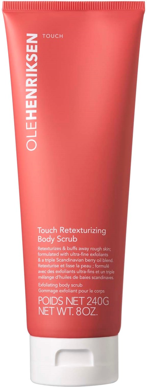 En korallfärgad tub av Ole Henriksen Touch Retexturizing Body Scrub med vit text och vit kork.