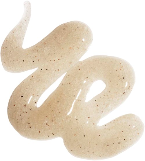 Krämfärgad lotion med bruna prickar utbredd på en vit bakgrund.