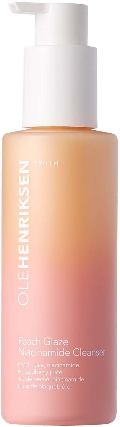 En ferskenfarget hudpleiefleske med hvit pumpe merket OLEHENRIKSEN Peach Glaze Nacinamide Cleanser.