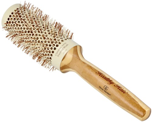 En rund hårborste med trähandtag och spetsiga borst, märkt "Healing Hair."