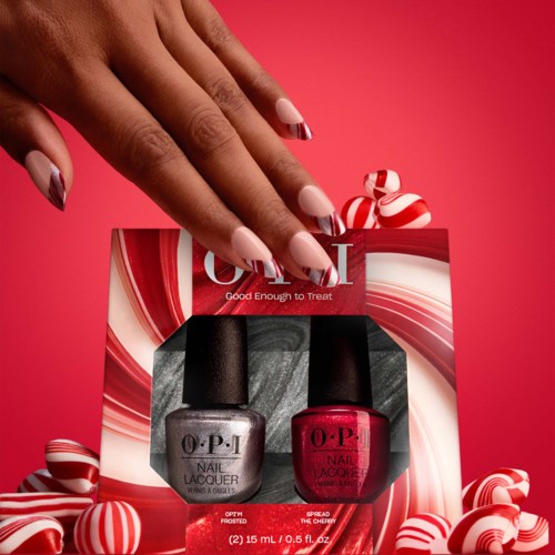 Twee flesjes nagellak, één grijs en één roze, in een cadeauverpakking omringd door rood-wit gestreepte snoepjes.