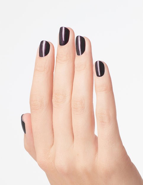 En hand med fyra synliga fingrar, målade med mörk lila eller svart nagellack, mot en ljus bakgrund.