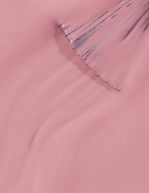 En rosa bakgrund med en kurvad, mörk streck och små ljus fläckar, möjligen en närbild av en texturerad yta.