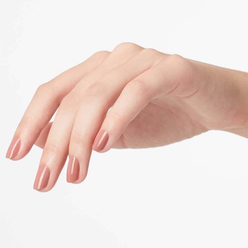 Hand med välvårdade naglar, fingrar lätt böjda, ljus hudton, enfärgad bakgrund.