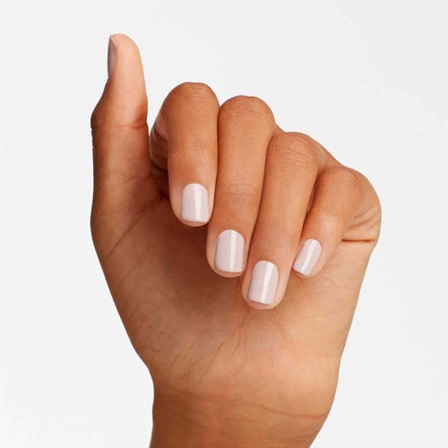A hand with four fingers visible, showing nails painted with white nail polish, against a plain background.