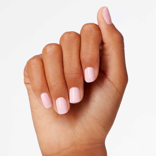Close-up van een hand met lichtroze nagels, vingers licht gekruld, schoon en goed verzorgd.