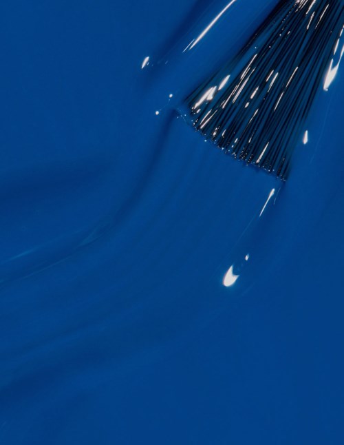 En blå overflate med en kluster av tynne svarte linjer og striper, noen hvite reflekser, og en dråpe.