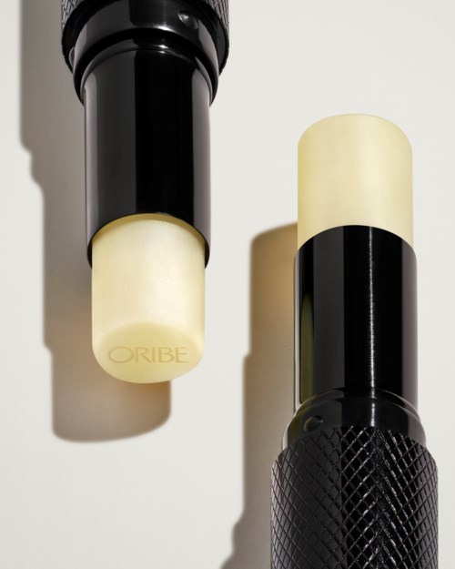 Två svarta och vita stavar med ett texturerat handtag och glödande ändar, märkta med 'ORIBE'.