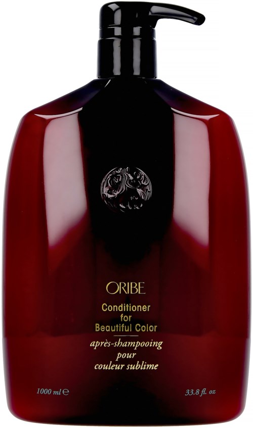 A large red bottle of Oribe conditioner with black pump, labeled for beautiful hair color, in simple and elegant design.