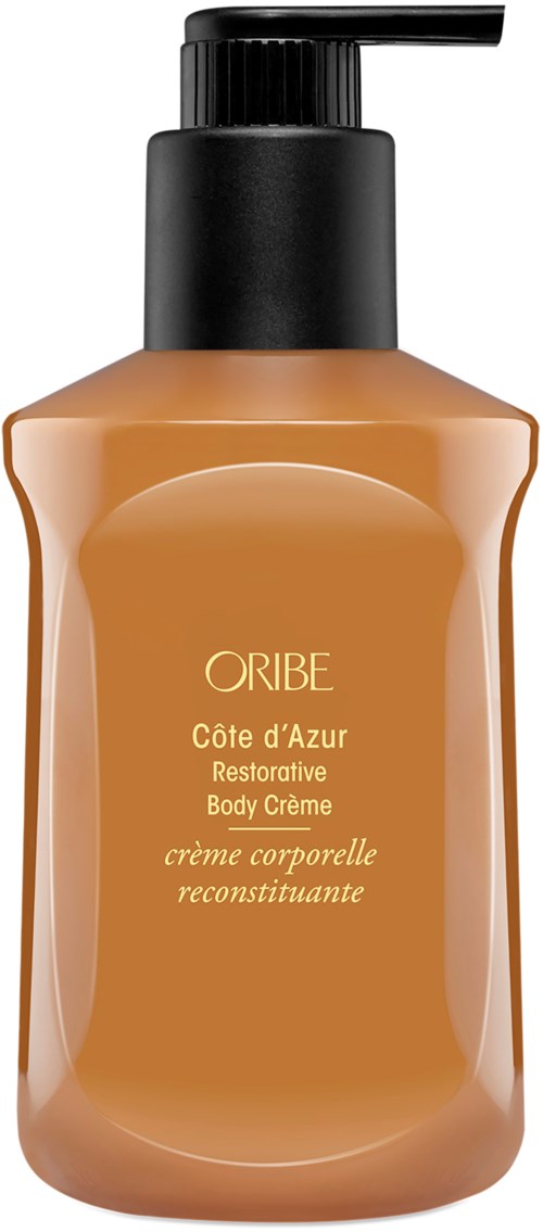 A sunscreen lotion bottle with a black pump, labeled 'ORIBE Côte d'Azur Restorative Body Crème', in a light brown color.
