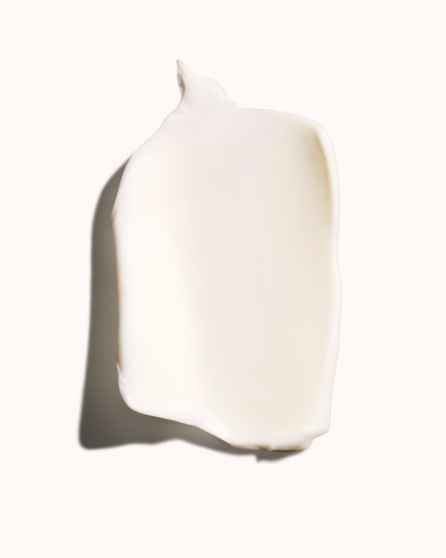 A white bar of soap with a curved top, placed on a plain light background.