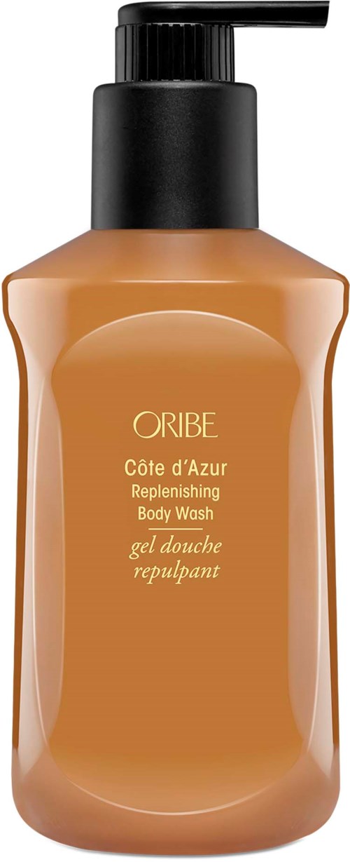 En beige kroppsvaskflaske med svart pumpe, merket Oribe Côte d'Azur Replenishing Body Wash.